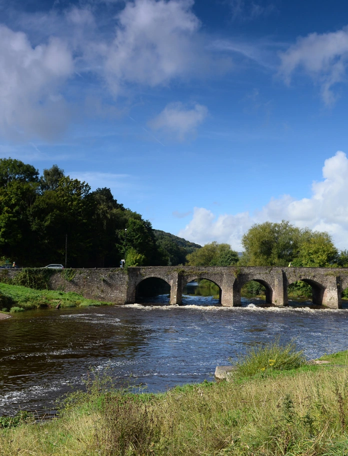 Man fishing in front of bridge over the River Usk, Abergavenny.