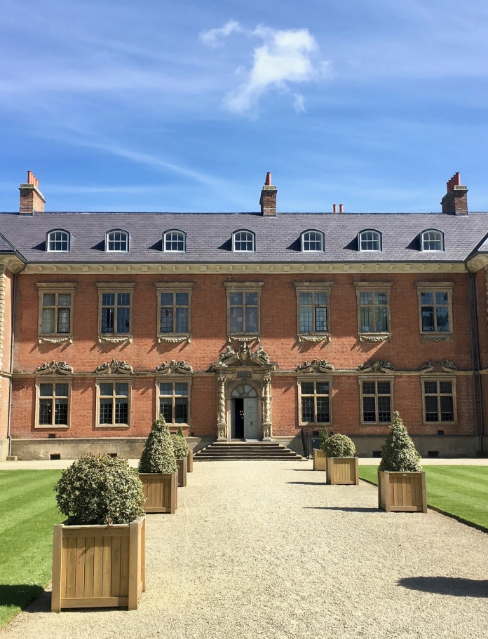 A red bricked mansion house from the front.