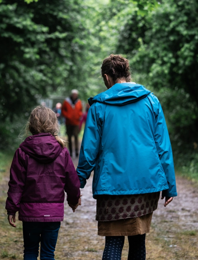 People walking along a woodland path.