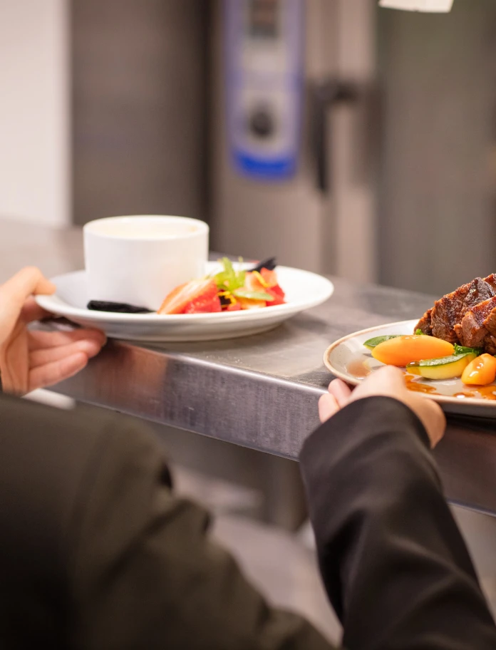 Restaurant food being collected by a waitress