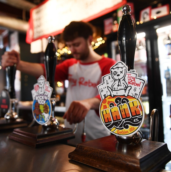 A man behind a bar pouring a pint