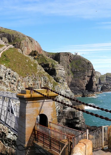 A bridge to a lighthouse over the sea.