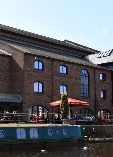 buildings, outside seating and parasols and canal boat on canal.
