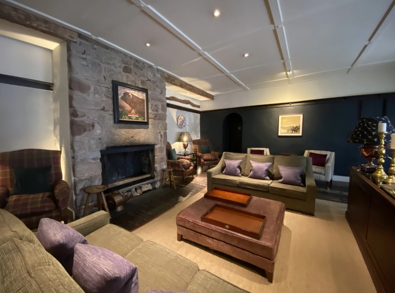 Interior of an old pub with comfy sofas and a bar.