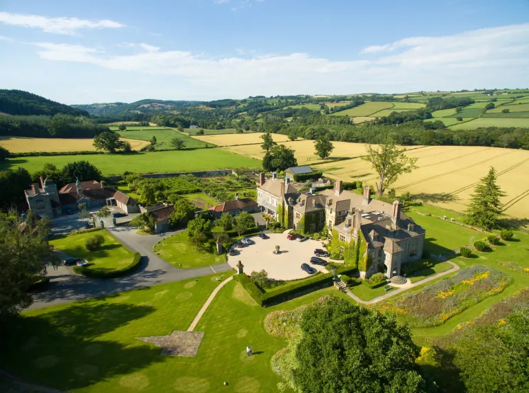 drone shot of stately hall and surrounding countryside.