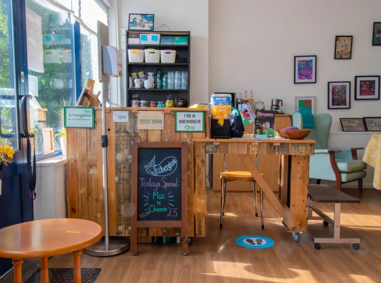 The interior of a cafe with wooden floor and reception desk.