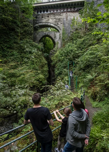 Family looking up a Devil's Bridge from railings beneith