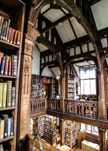 Wooden shelves and ceiling with books (library)