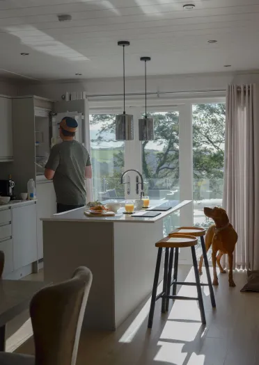 man and dog in kitchen in holiday lodge.
