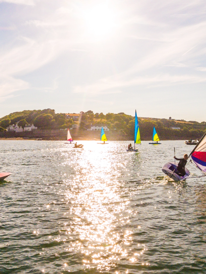 Several small boats sailing off the coast.
