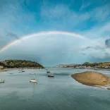 A huge rainbow over an estuary town.